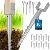 A close-up of metal ground anchors with a wooden post attached, set against a backdrop of green grass and soil. Several other anchors and screws are also visible. Produktbild-Vorschau