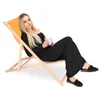 A woman relaxing in a deck chair with a mug. Produktbild-Vorschau
