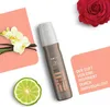 A Wella Eimi Perfect Setting hairspray bottle is displayed with decorative elements like orchids, vanilla beans, a lime slice, and a rose, along with marketing text. Produktbild-Vorschau