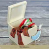 A wooden box filled with ribbons, next to a decorative duck figurine. Produktbild-Vorschau