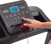 A close-up of a person's hand pressing a button on a treadmill console. Produktbild-Vorschau