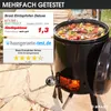 A black outdoor cooking pot filled with stew, set on a stone patio with a fire burning inside. Produktbild-Vorschau