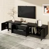 A black TV stand with open doors and drawers, displaying books and decorative items, in a living room setting with a TV mounted on the wall. Voir les images du produit