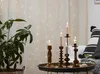 A cozy indoor scene with candles and a plant, illuminated by fairy lights. Produktbild-Vorschau