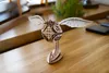 A wooden model of a Golden Snitch from Harry Potter sits on a wooden table. Náhled obrázku produktu