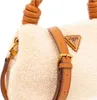 A close-up view of a beige fuzzy handbag with brown leather accents. Produktbild-Vorschau