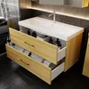 A modern bathroom vanity with an open drawer showing towels and bottles. Produktbild-Vorschau