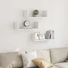 Three white U-shaped wall shelves are mounted on a white wall above a light-colored sofa with pillows. Náhled obrázku produktu