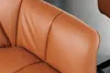 A close-up view of the armrest and seat of a cognac-colored leather chair. Produktbild-Vorschau