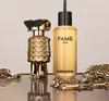 A perfume bottle and its refill are displayed on a reflective surface with gold chains. Voir les images du produit