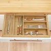 A bamboo cutlery organizer filled with kitchen utensils in an open drawer. Podgląd zdjęcia produktu