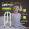 An elderly woman is sitting on a bed next to a white bed rail, with text overlays highlighting product features. Náhled obrázku produktu