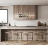 A modern kitchen with a wooden island and stools, featuring a sleek pendant light. Produktbild-Vorschau