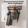 A wooden coat rack mounted on a wall, displaying a coat, backpack, hat, and umbrella. Produktbild-Vorschau
