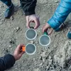 Zwei Personen halten die "Climbing Mug" von YY Vertical in den Händen; während eine dritte Person auf dem Boden steht. Die Tassen sind in verschiedenen Farben und für Kletterfreunde gedacht. Podgląd zdjęcia produktu
