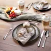 A table setting with cutlery, plates, napkins, and drinks, suggesting a meal or gathering. Produktbild-Vorschau