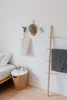 A bedroom corner with a bed, a nightstand, and wall hooks. Náhled obrázku produktu