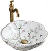 A decorative ceramic sink with a floral and bird pattern, paired with a brass-colored faucet. Anteprima dell’immagine prodotto