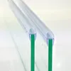 Close-up view of two clear plastic shower door seals attached to green glass panels. Podgląd zdjęcia produktu