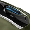A close-up view inside a green backpack, showing a zippered pocket with a blue pouch and a key attached. Produktbild-Vorschau