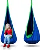 A young girl sits in a blue and green hanging pod chair, with another identical chair shown empty next to it. Produktbild-Vorschau