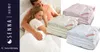 A couple cuddling in bed, with folded blankets displayed. Podgląd zdjęcia produktu
