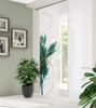 A room interior with a plant and a sliding panel curtain with a botanical print. Produktbild-Vorschau