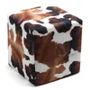 A cube-shaped ottoman with a cowhide pattern. Podgląd zdjęcia produktu