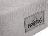 A close-up view of a fabric label attached to a textured gray fabric. Náhled obrázku produktu