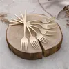 A set of gold forks arranged on a wooden slice. Anteprima dell’immagine prodotto