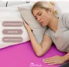 A woman sleeping on a bed with a pink sheet. Produktbild-Vorschau