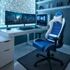 A gaming setup with a desk, monitors, computer, and a gaming chair. Produktbild-Vorschau