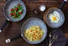 A top-down view of three frying pans on a wooden table, each containing different food items. Produktbild-Vorschau