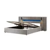 A grey upholstered bed frame with its storage compartment open, revealing the hydraulic lift mechanism and mattress slats. The headboard features integrated blue LED lighting. Produktbild-Vorschau