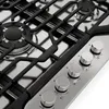 A close-up, angled view of a stainless steel gas cooktop with black grates and control knobs. Náhľad obrázku produktu