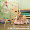 Two young girls are playing with a wooden climbing set indoors. Náhľad obrázku produktu