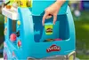 A hand is placing a small container of Play-Doh into a blue toy ice cream truck. Náhľad obrázku produktu