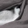 A close-up view of the inside of a dark gray bean bag chair, showing the white mesh lining and the EPS bead filling. Produktbild-Vorschau