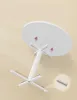 An illustration showing the underside of a white round table with its white pedestal base and legs being assembled with screws. Produktbild-Vorschau