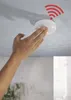 A hand is shown installing a white smoke detector on a ceiling. Náhľad obrázku produktu