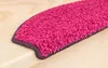 A close-up view of a pink shaggy stair mat on a wooden stair. Produktbild-Vorschau