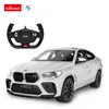 A white BMW X6 M remote-controlled car and its steering wheel controller are displayed against a white background. Podgląd zdjęcia produktu
