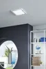 A modern bathroom with a square ceiling light, a dark gray wall, a large oval mirror, and a white shelving unit with various bathroom items. Produktbild-Vorschau