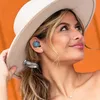 A woman wearing a white hat and a blue earbud, looking up and to the side. Anteprima dell’immagine prodotto