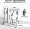 A white round folding table with metal legs, shown in both upright and folded positions, with dimensions indicated. Produktbild-Vorschau