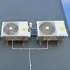 Two outdoor air conditioning units mounted on a gray wall. Podgląd zdjęcia produktu