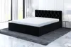 A black upholstered bed with a white mattress is shown in a modern bedroom setting. Produktbild-Vorschau