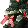A close-up view of a decorated artificial Christmas tree with red and white striped ribbons, holly leaves with red berries, and eucalyptus leaves. Náhled obrázku produktu