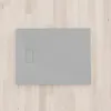 A flat gray shower tray is placed on a light wood floor. Produktbild-Vorschau