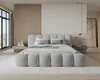 A modern bedroom with a large upholstered bed. Voir les images du produit